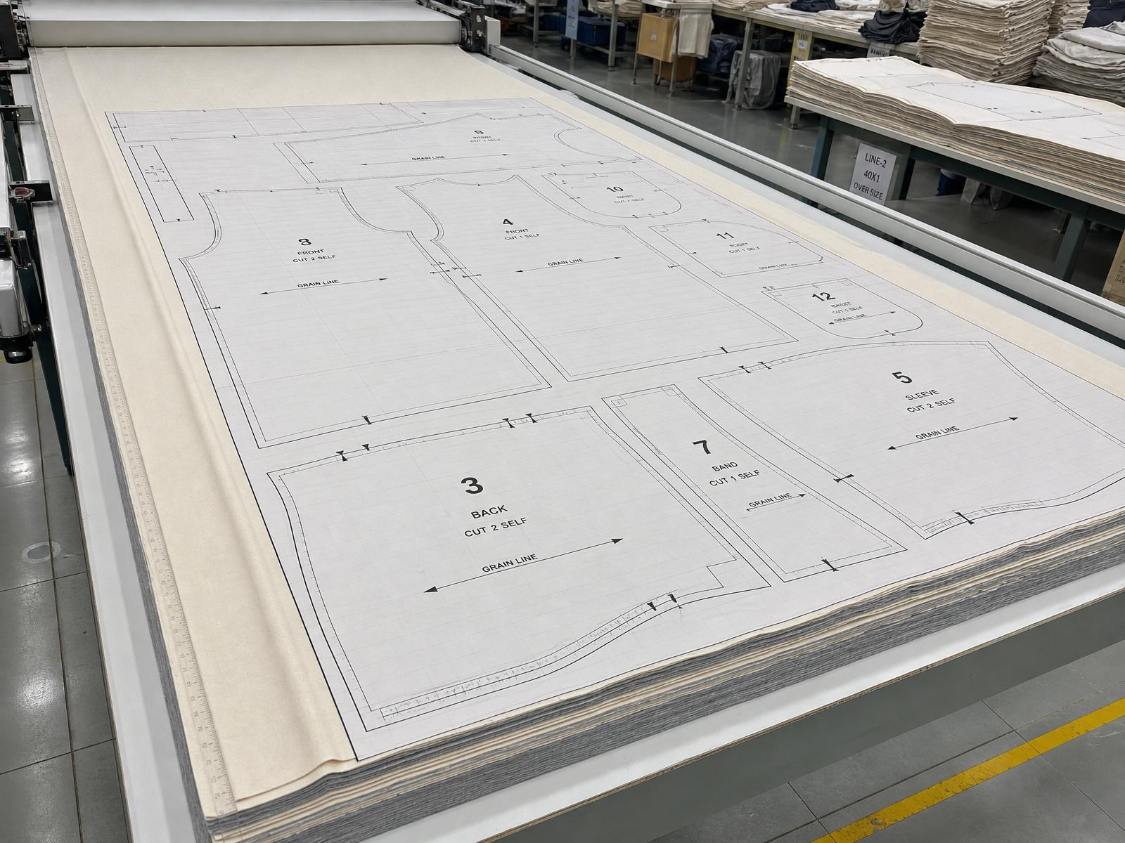 Cutting room with nested pattern marker on a spreading table